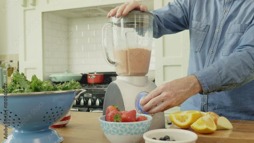 Man Using Blender By Various Fruits And Vegetable At Table Man Using Blender By Various Fruits And Vegetable At Table