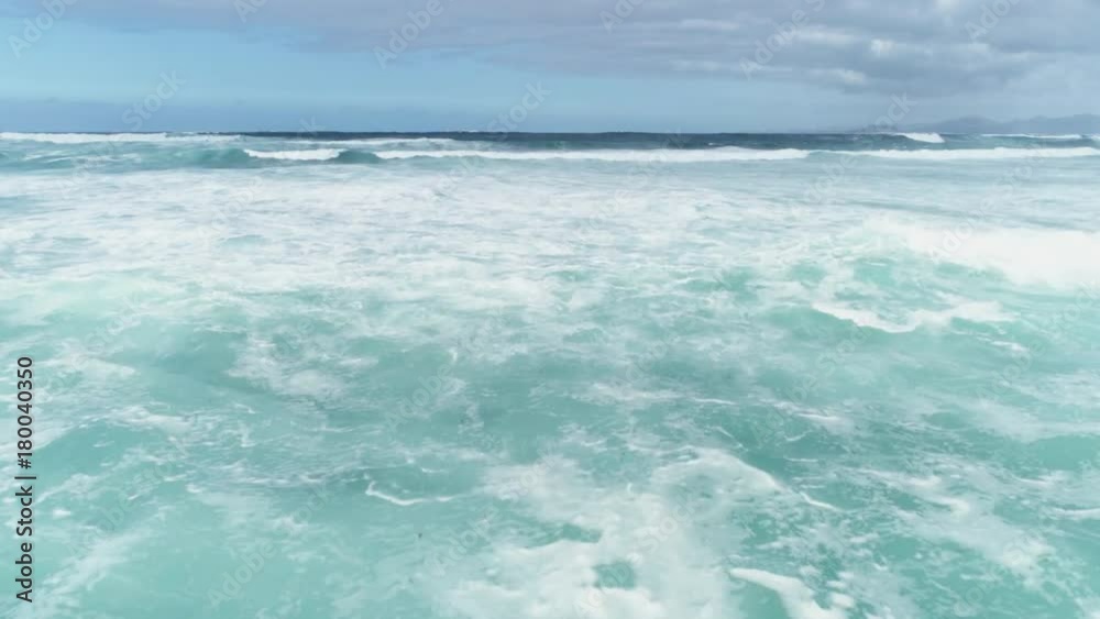 Aerial Drone Footage Of Waves Rushing Towards Shore Against Sky