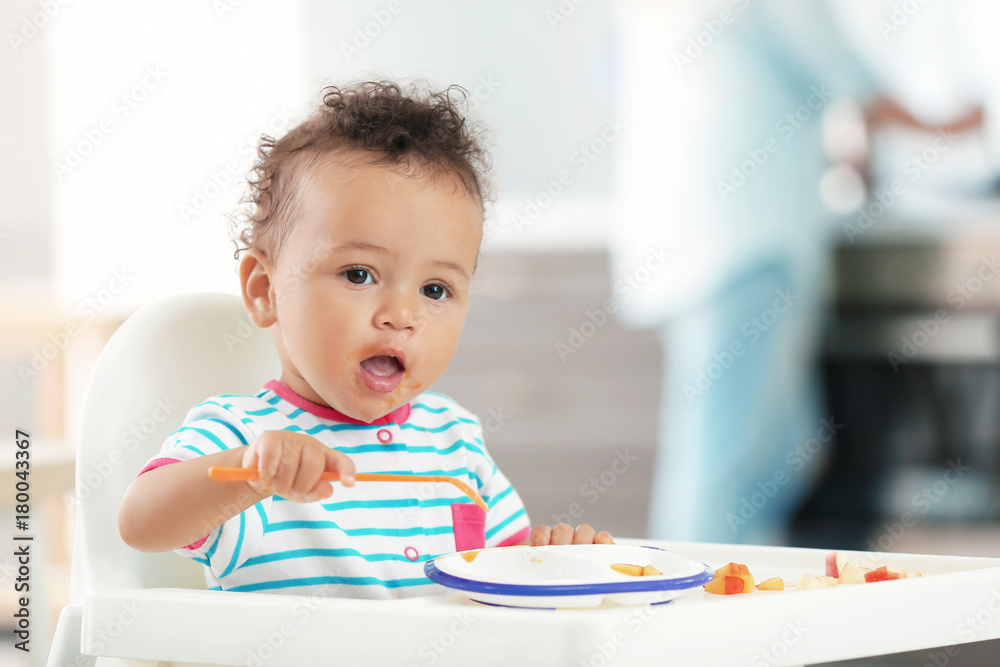 Little baby eating puree indoors Little baby eating puree indoors