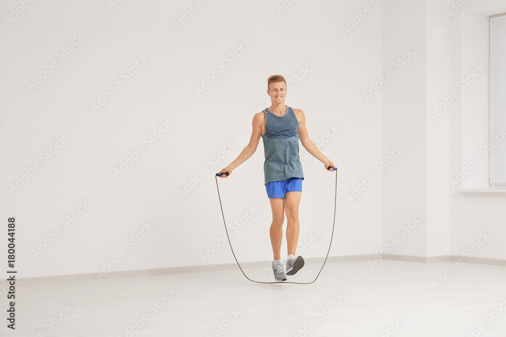 Young man in sportswear with jumping rope indoors Young man in sportswear with jumping rope indoors
