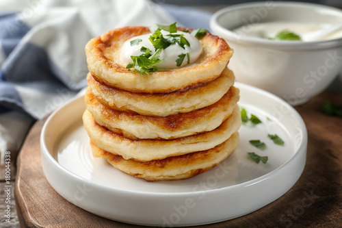 Plate with Hanukkah potato pancakes on table