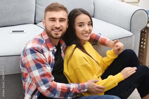 Young couple near sofa at home