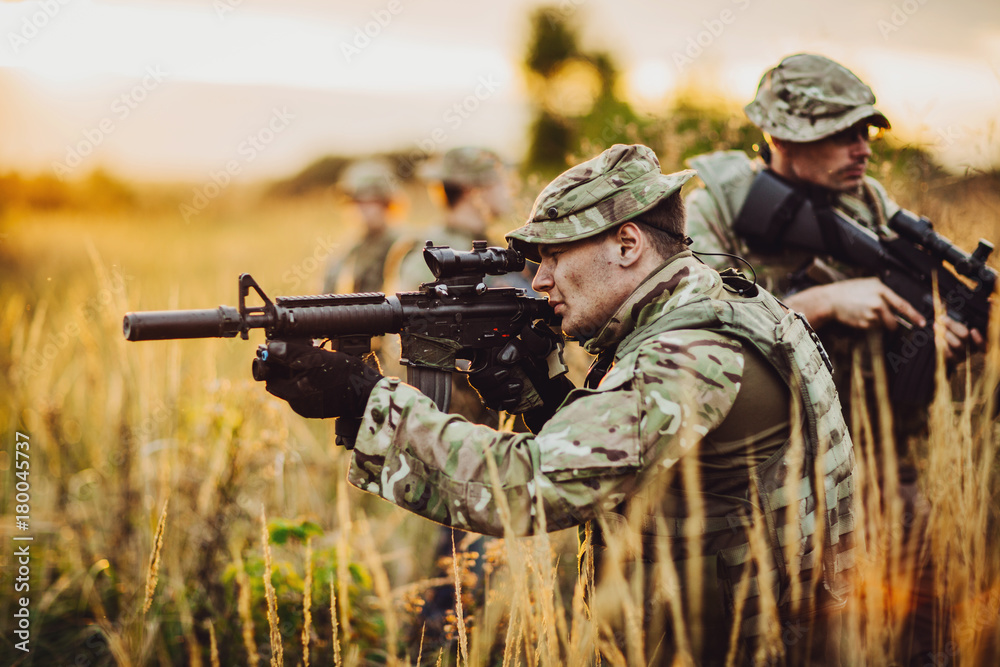 Fototapeta premium Rangers shooting with his weapon, rifle at sunset. War, army, military concept.