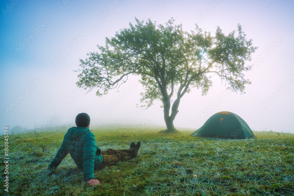 Fototapeta premium Man sitting on a frozen meadow