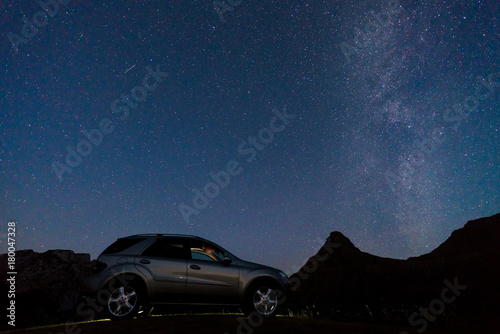 Night landscape with a car on the background of the milky way
