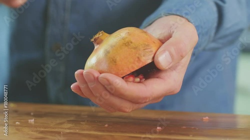 Man Banging Back Of Pomegranate With Spoon To Release Seeds