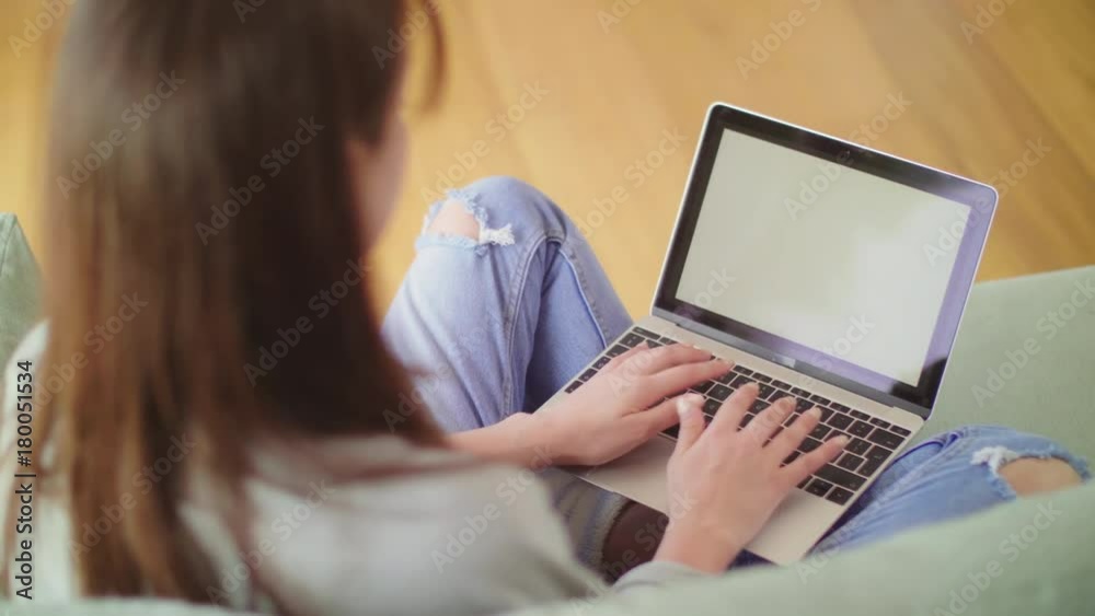 Over The Shoulder View Of Blogger Using Laptop On Sofa Over The Shoulder View Of Blogger Using Laptop On Sofa