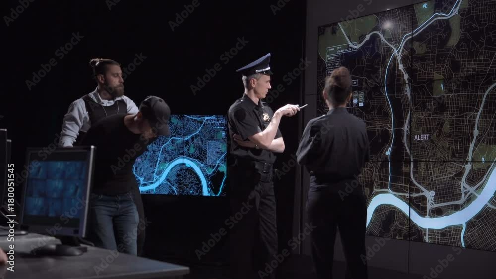 Two proficient police officers analyzing and watching a digital ...