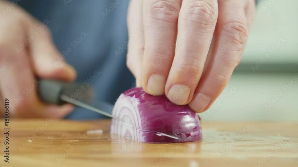 Man's Hands Cutting Onion With Sharp Knife On Chopping Board Man's Hands Cutting Onion With Sharp Knife On Chopping Board