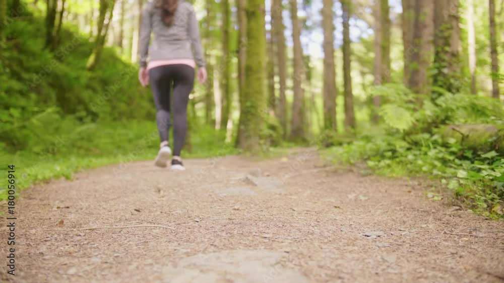 Lockdown Shot Of Sporty Woman Walking On Forest Trail Lockdown Shot Of Sporty Woman Walking On Forest Trail