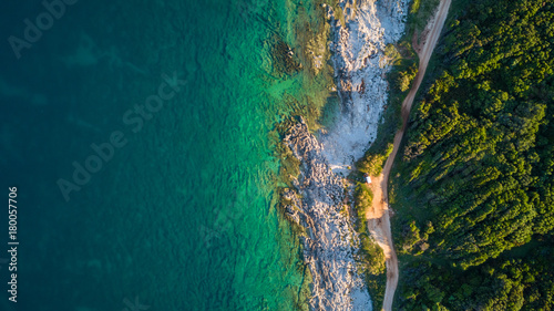 Drone shot of a rocky headland at daylight with emerald color water
