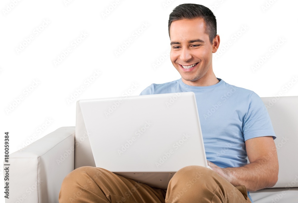 Smiling Man Using Laptop while Sitting on a Couch Smiling Man Using Laptop while Sitting on a Couch