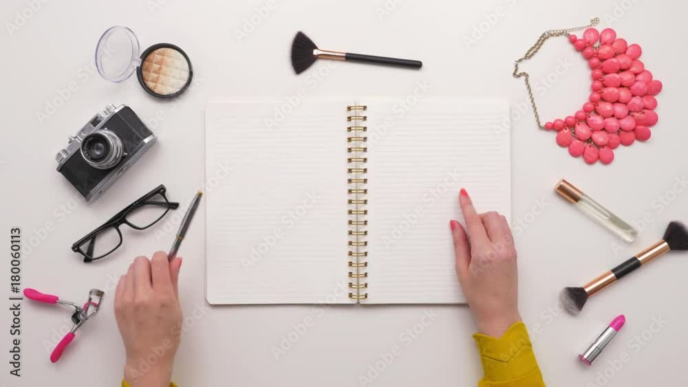 Overhead Top View Of Female Writing In Notebook By Beauty Products