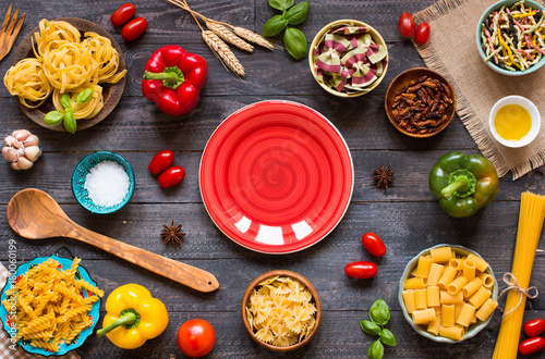 Different types of pasta with various types of vegetables, health or vegetarian concept on a wooden background,  Top view