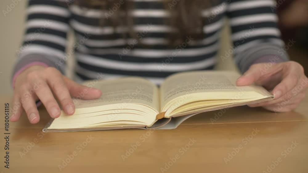 Lockdown Shot Of Woman Reading Book At Wooden Table