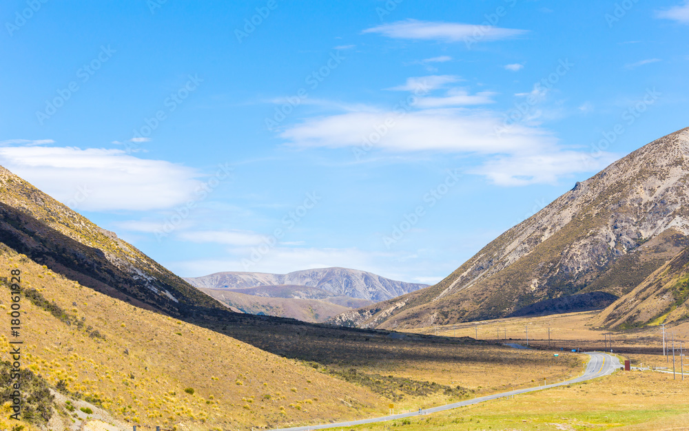 Rural Scene of Asphalt Road with Meadow and Mountain Range, South Island, New Zealand	
