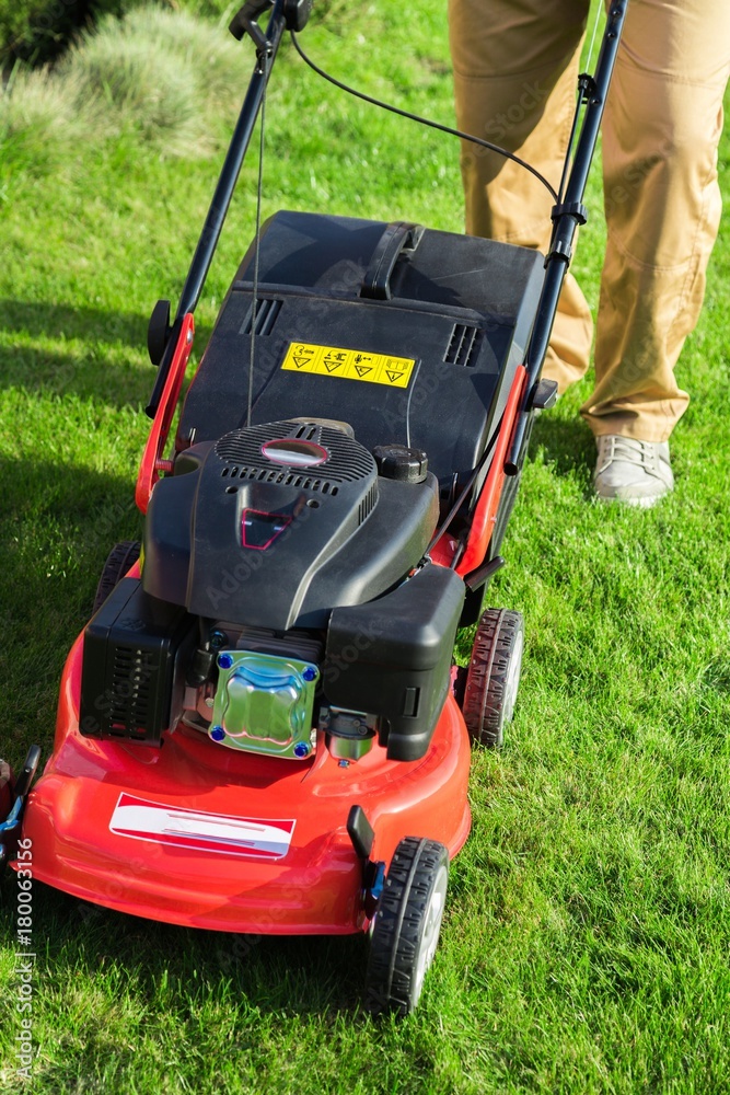 Closeup of a Gardener Using a Lawn Mower Closeup of a Gardener Using a Lawn Mower