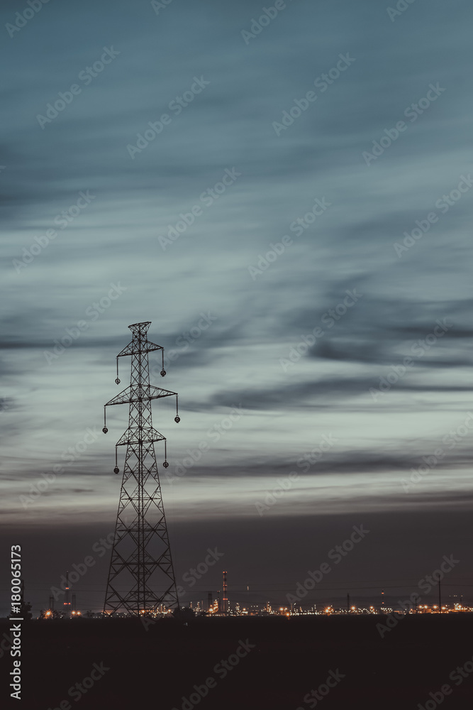 big electricity tower with city in background