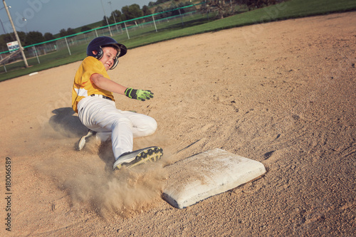 Foto Youth Baseball playing sliding back to base.
