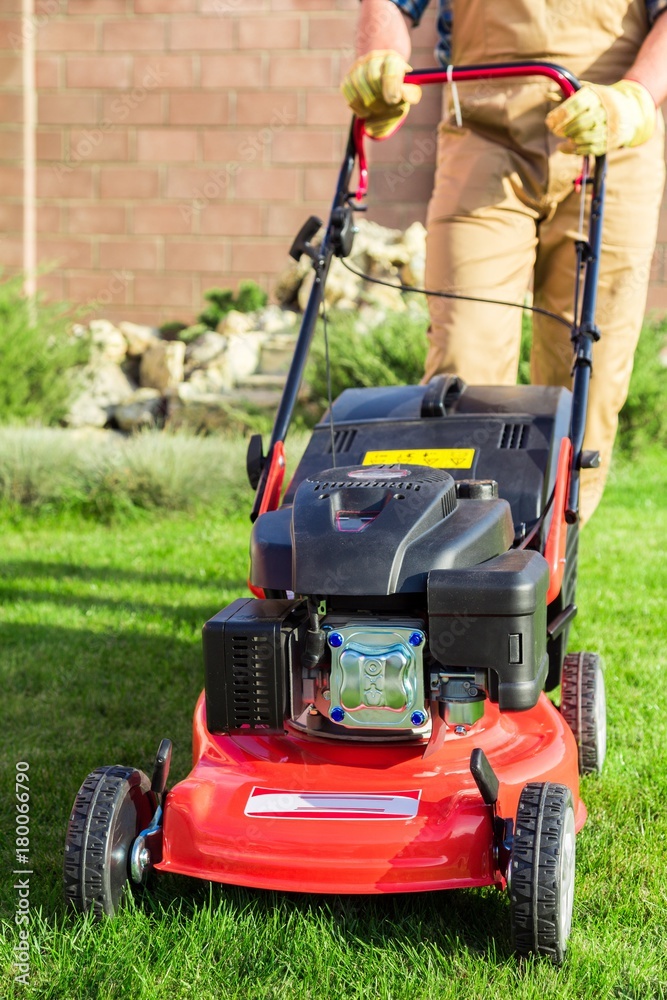 Closeup of a Gardener Using a Lawn Mower Closeup of a Gardener Using a Lawn Mower
