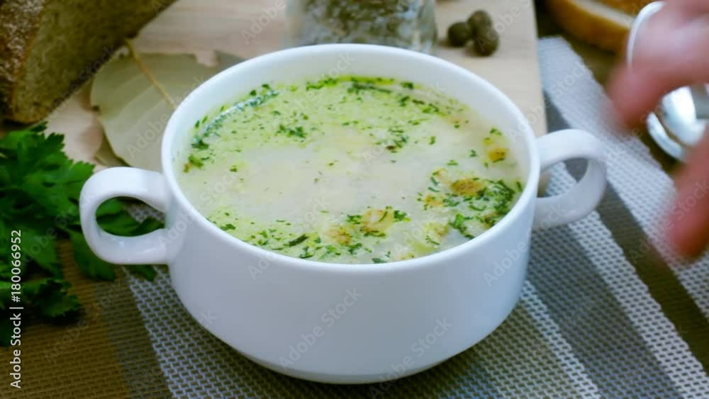 Mushroom soup with croutons in a white dish is on a wooden table. Tripod pan filming. Mushroom soup with croutons in a white dish is on a wooden table. Tripod pan filming.