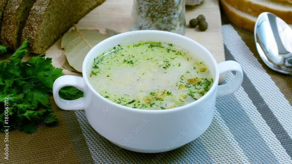 Mushroom soup with croutons in a white dish is on a wooden table. Tripod pan filming. Mushroom soup with croutons in a white dish is on a wooden table. Tripod pan filming.