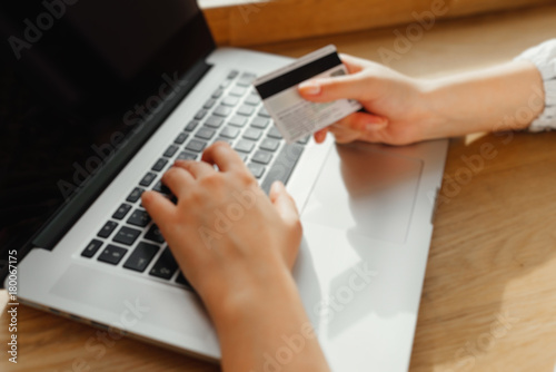 Hands of woman holding credit card and using laptop. Online shopping