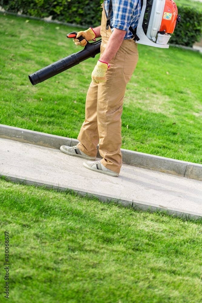 Fototapeta premium Closeup of a Gardener Using a Backpack Blower