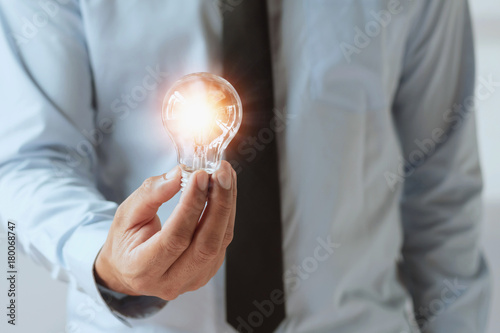 hand businessman holding light bulb, innovation and inspiration idea concept