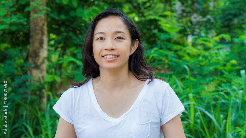 Asian woman long hair with facial epression green nature background Asian woman long hair with facial epression green nature background