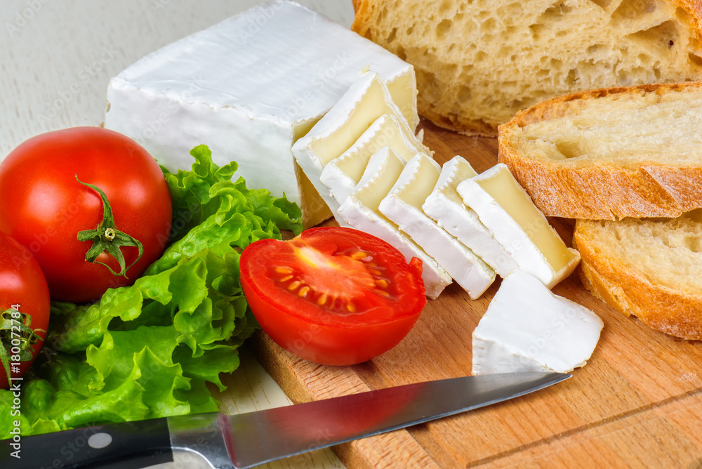 Breakfast from bread, cheese, tomatoes and all-over salad on a wooden table closeup. Breakfast from bread, cheese, tomatoes and all-over salad on a wooden table closeup.