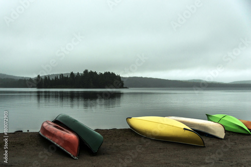 Canada Ontario Lake two rivers grey morning dark atmosphere Canoe Canoes parked beach water in Algonquin National Park photo