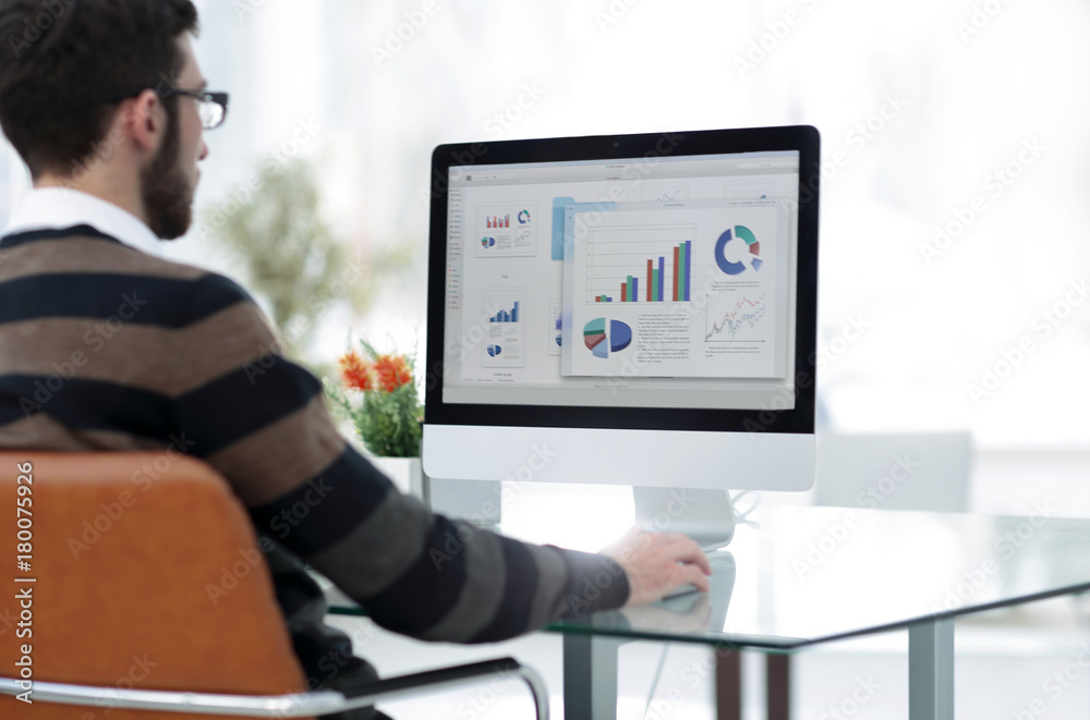 businessman analyzing graphs on computer at desk businessman analyzing graphs on computer at desk