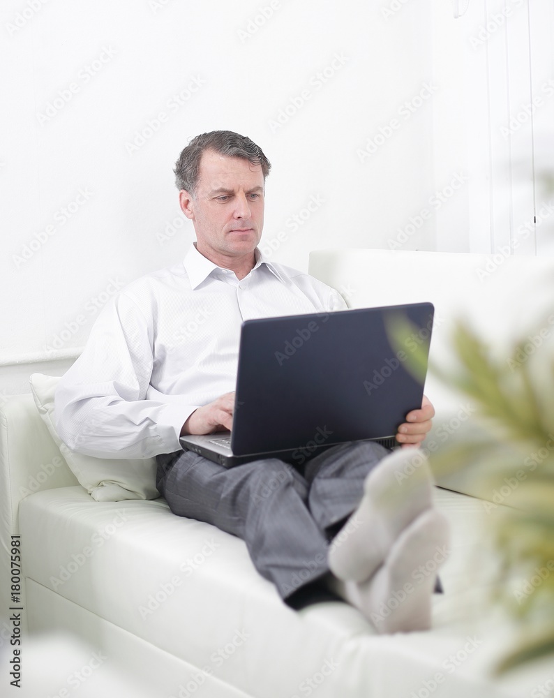 businessman working on laptop while sitting in a hotel room businessman working on laptop while sitting in a hotel room
