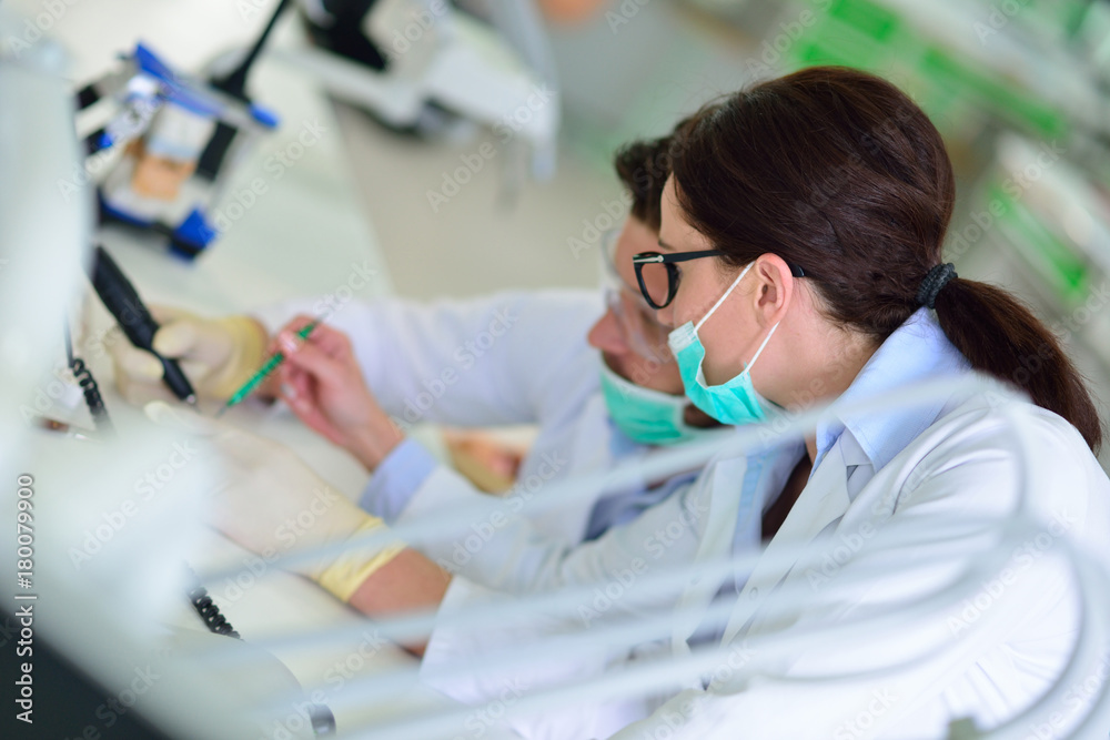 Dental prosthesis, dentures, prosthetics work. Prosthetics hands while working on the denture Dental prosthesis, dentures, prosthetics work. Prosthetics hands while working on the denture