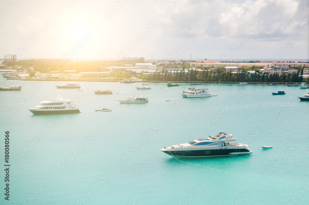 Obraz premium Tropical islands and atolls in Maldives in Indian Ocean from aerial view. Boats on the water. Piece of paradise on the Earth. Good choice for vacation. Beautiful top view for wallpaper.