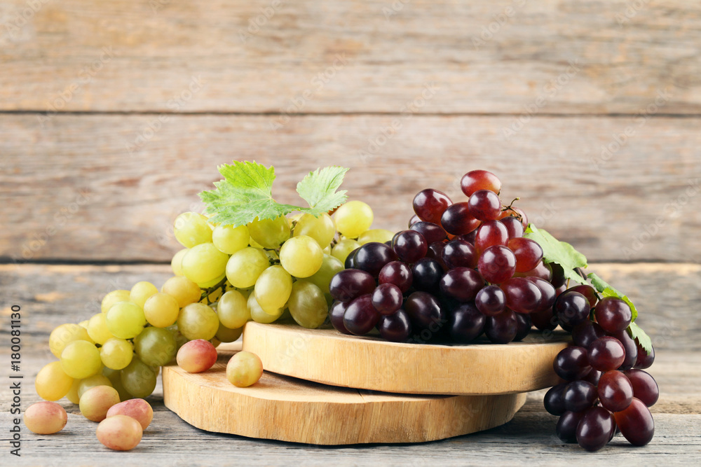 Green and red grapes on grey wooden table Green and red grapes on grey wooden table