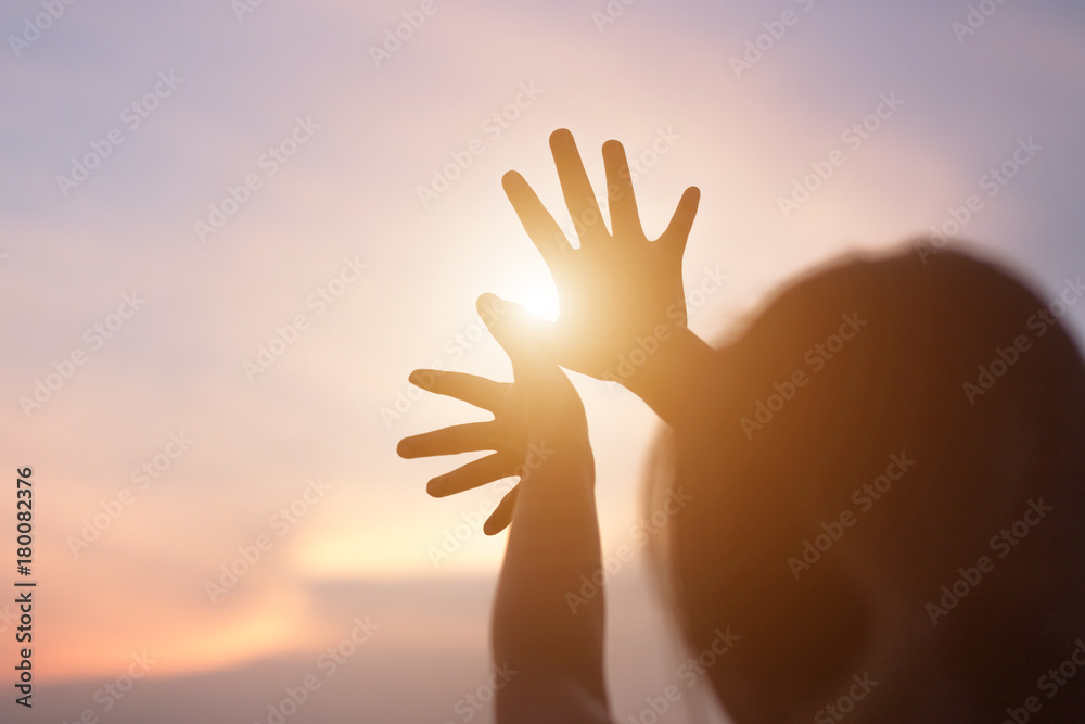 hands forming a shape with sunset silhouette