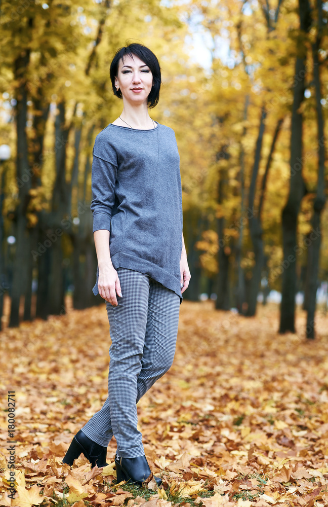 girl stand in autumn park with yellow trees, fall season girl stand in autumn park with yellow trees, fall season