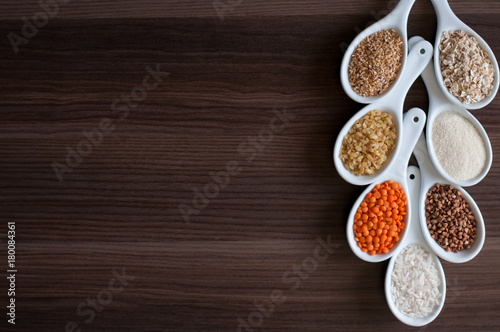 Cereals in a white dish on a dark wooden background.