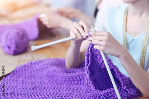 Bright colors. Amazing bright purple knitted sweater in the hand of a talented creative woman