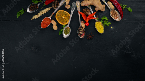 Fototapeta Naklejka Na Ścianę i Meble -  Spices and herbs. A large assortment of spices. Indian cuisine. On the wooden table. Top view. Free space for text.