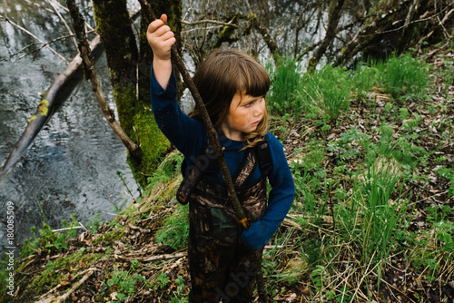 Girl playing with a stick in the woods photo