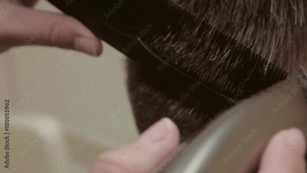 The hairdresser woman makes a haircut to the man.Trim the tips of the