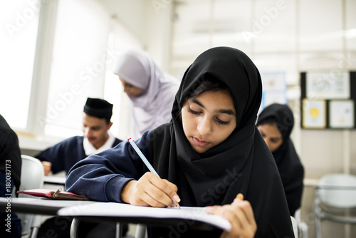 diverse muslim children studying in classroom photo