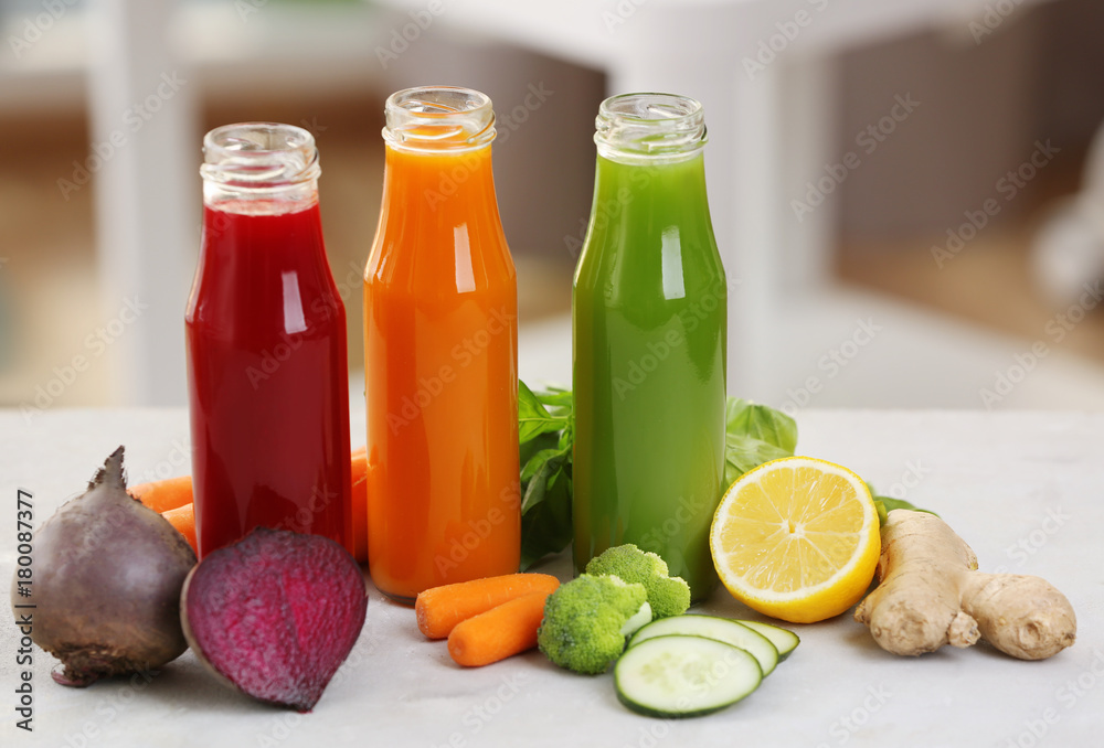 Bottles with various fresh vegetable juices on table Bottles with various fresh vegetable juices on table