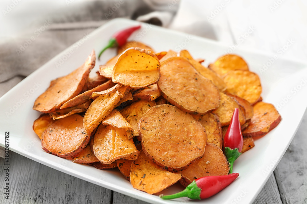 Plate with yummy sweet potato chips on table Plate with yummy sweet potato chips on table