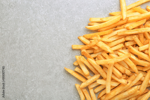 Yummy french fries on grey background