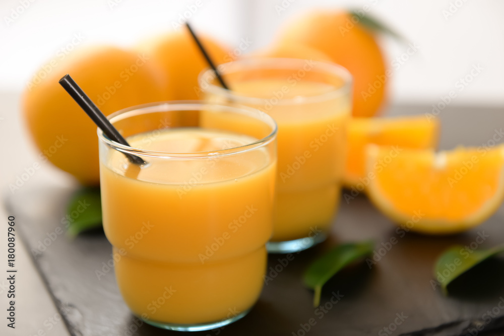 Glasses of fresh orange juice on slate plate Glasses of fresh orange juice on slate plate
