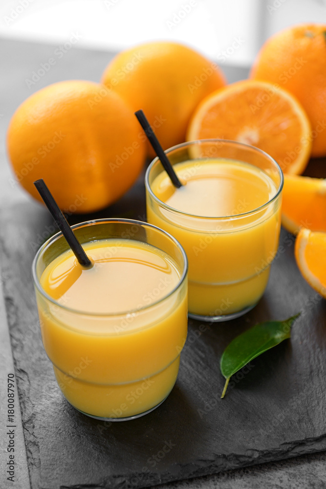 Glasses of fresh orange juice on slate plate Glasses of fresh orange juice on slate plate